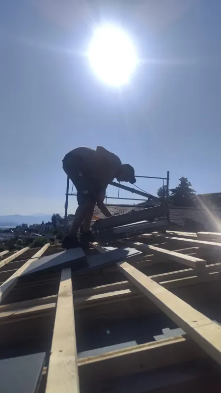 Dachdecker von Quality Bedachungen bei der Arbeit im Gegenlicht
